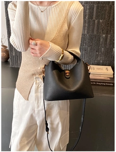 Detail of black lychee grain bucket bag with gold hardware and adjustable strap