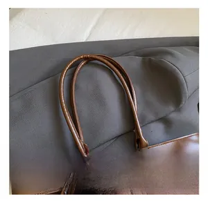 Close-up of brown suede and leather stitching tote bag with long rounded handles