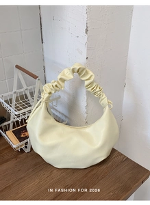 Detail view of the pale yellow croissant bag with a stylish pleated scrunchie handle