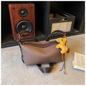 Détail du sac en cuir marron avec garniture dorée et breloque cheval jaune incluse