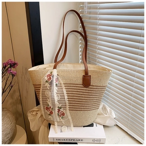 Detail of striped straw tote with brown leather handles and rose embroidery lace scarf