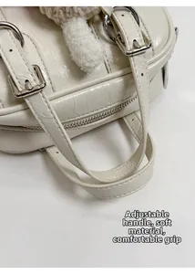 Detail of white wrinkled leather handbag with silver buckle and adjustable strap