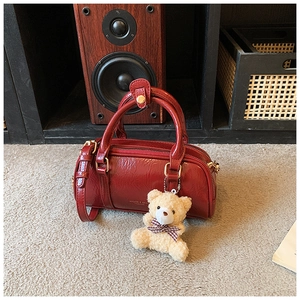 Mini sac Boston en cuir verni rouge avec pendentif ours en peluche et poignée détaillée