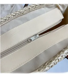 Detail view of smooth metal zipper and durable fabric lining inside the woven tote bag