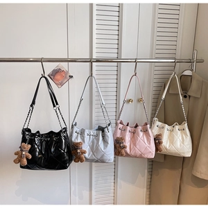 Quilted bucket bags in black, blue, pink and white with metal chains and bear charms