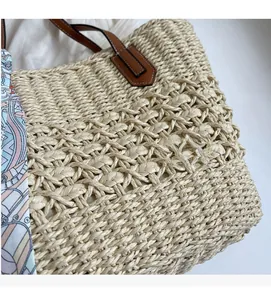Detail of straw woven tote with blue pink silk scarf and premium brown leather handle