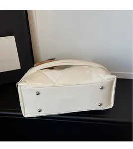 Detailed view of the quilted bag base featuring four silver protective metal feet