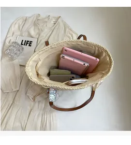 Detail view of woven straw tote bag interior with large capacity and floral scarf detail