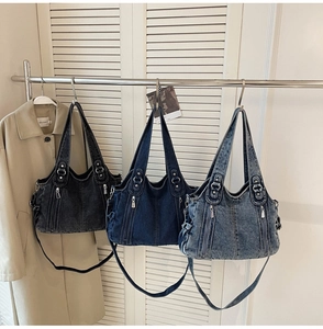 Detailed close-up of retro washed denim handbags in three colors on a metal hanger