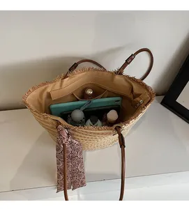 Spacious woven straw tote bag interior with multiple pockets and decorative silk scarf
