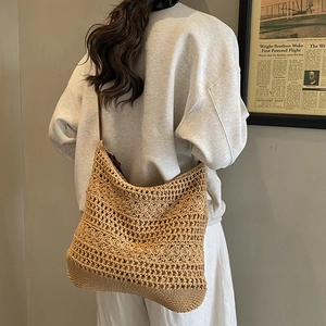 Dettaglio della borsa tote bohémien in paglia intrecciata con tracolla in pelle