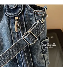 Detailed macro view of adjustable silver metal buckle on a dark blue denim shoulder bag