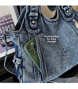 Detail of vintage denim tote front pocket with phone for storage convenience