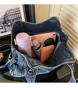 Macro view showing spacious interior of denim tote bag with daily essentials inside