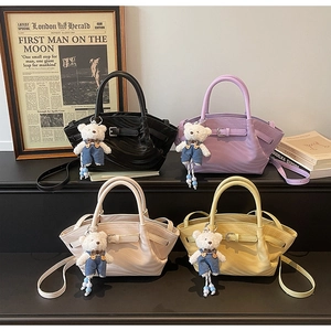 Macro detail of four ruched PU leather handbags in black, lilac, white, and yellow