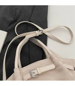 Detail of cream white PU leather tote bag showing adjustable strap and silver metal buckle