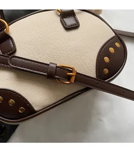 Detail of adjustable leather shoulder strap with vintage gold rivets and buckles