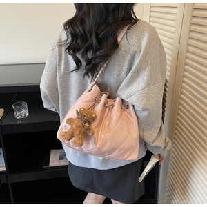 Pink quilted bucket bag detail with glossy finish, chain strap and cute bear charm pendant