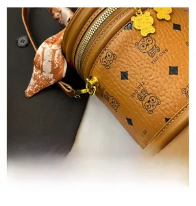 Détail du sac seau en cuir grainé marron avec imprimés panda et poignée en soie