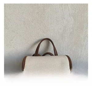 Detail showing the comfortable top handle and contrast stitching on the flap of the backpack