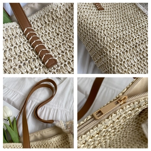 Detail of woven straw texture, leather handles, and metal zipper on bucket bag