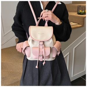 Detail of cream and pink drawstring backpack in pebbled leather with buckle pockets