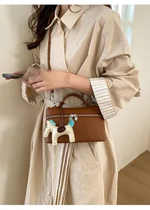 Sac boîte en cuir grainé marron avec fermeture éclair argentée et breloque cheval