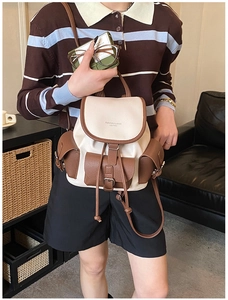 Detail of color-block vintage backpack in cream and brown with drawstring closure