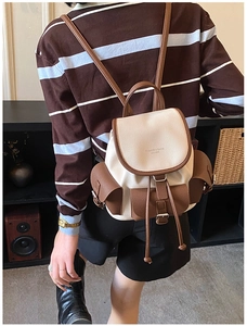 Detailed close-up of a vintage contrast color backpack with drawstring and metal buckles