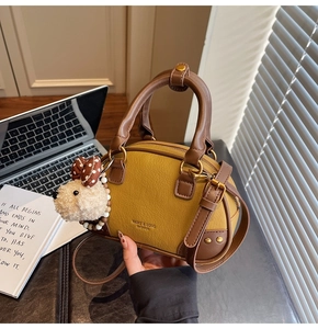 Close-up of Boston bag with ginger leather texture, branded logo and cute puppy pendant