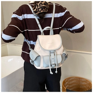 Rear view of model wearing a vintage-style cream and grey-blue large capacity backpack