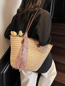 Large straw tote bag with striped weave and decorative scarf for beach vacation style
