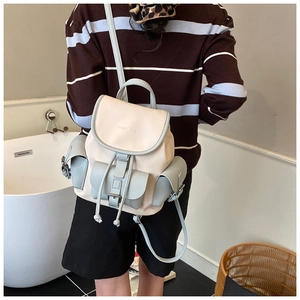 Detail view of a vintage color-block backpack worn by a model in a minimalist setting