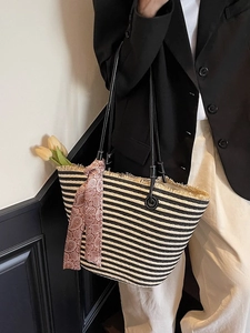 Large black and white striped straw tote bag with leather straps and decorative scarf