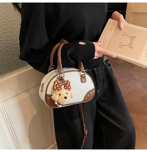 Detail of contrast stitch bowling bag with adjustable strap and cute puppy pendant