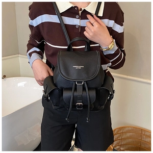 Detail of a vintage black leather backpack with drawstring closure and large front pocket