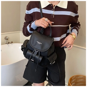 Detailed view of black lychee texture leather backpack with drawstring and flap closure