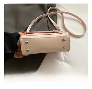 Detailed bottom view of pink leather handbag with four silver metal protective studs