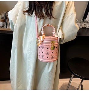 Détail du sac seau rose avec motifs d'ours et poignée décorée d'un foulard en soie