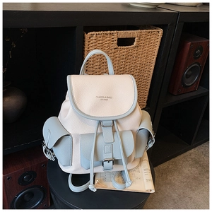 Detailed view of the contrast color faux leather backpack with drawstring and metal buckles