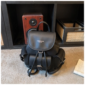 Close-up of black lychee grain leather backpack with magnetic flap and front pocket