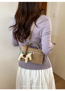 Vue détaillée de dos d'un sac à main en cuir grainé avec un pendentif cheval chic