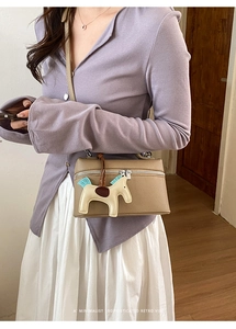 Sac à main en cuir litchi kaki avec pendentif cheval décoratif et détail de pompon bleu