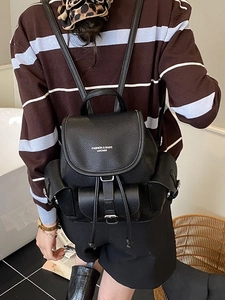 Retro black leather backpack with drawstring closure and fashion lettering on the flap