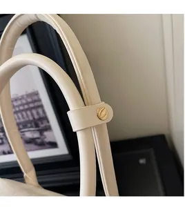 Detail of durable PU leather bag handle with elegant round gold metal buckles