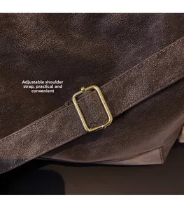 Detail of vintage brown leather bag with adjustable strap and golden metal buckle