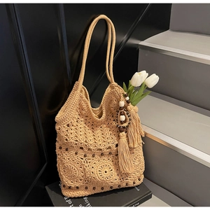 Dettaglio della borsa intrecciata con perline di legno, nappe e fodera interna