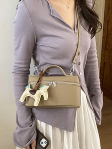 Sac à main en cuir grainé beige avec bandoulière amovible et charm de cheval élégant