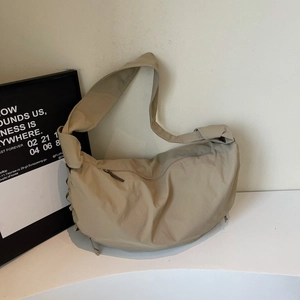 Détail d'un sac hobo kaki montrant le nœud de la bandoulière et la texture du tissu