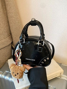 Chic black patent leather bowling bag with silver studs and a cute bear charm